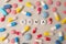 Pills with word Coma among others on beige background, flat lay