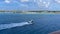 A pilot boat escorting a cruise ship into a caribbean island port