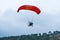 The pilot flies on a motorized parachute at a hot air balloon festival