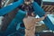 Pilot or mechanic in a full flight gear checks the propeller of his retro military aircraft before a flight.