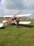 Pilot standing by historic biplane aircraft