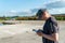 The pilot of an unmanned aerial vehicle holds a drone control panel in his hands. Flying a quadrocopter over an old abandoned