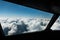 Pilots view out of the cockpit window toward clouds and blue sky above