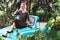 Pin-up girl wearing vintage clothes, sitting on old car.