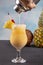 Pina Colada over wooden background garnished pineapple. A cocktail