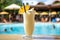pina colada poolside, with people sunbathing in the background