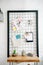Pinboard with drawings and glasses and wooden table in teenage room.