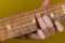 Pinch a chord on the guitar neck with your fingers on a yellow background