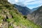 Pinchinuyok ancient Inca ruins surrounded by mountain peaks and clouds above the green canyon in Peru