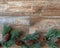 Pine border with pine cones on rustic wood background