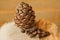 Pine cone and nuts on a napkin on the background of a brick wall.