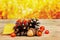 Pine cones, oak acorn and rowanberry on wooden board against bokeh background