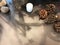 Pine cones, rocks, white candle, dried violet flower, part of tree log on wooden table