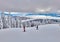 Pine forest covered in snow on winter season,Mountain landscape in Poiana Brasov with view over the the ski slope with skiers and