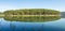 Pine forest island reflection on the lake with fresh air and nature, version panorama