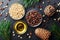 Pine nuts, oil and cedar cones on black table top view. Organic and healthy superfood.