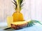 Pineapple half and pineapple juice in a glass over wooden background