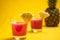 Pineapple juice in glass closeup near sliced fruit with spash and dripping liqid for summer vibes