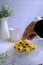 Pineapple rolled tart on the iron tray over white background with hand in frame.