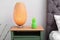 Pineapple shaped candle and lamp on bedside table