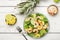 Pineapple shrimp salad with spinach, avocado and lime on white wooden kitchen table, top view. Healthy eating, balanced, clean