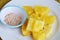 Pineapple slice dipping with mixed sugar salt and pepper on white plate