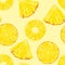 Pineapple slices on yellow background. Seamless pattern with pieces of tropical fruit.