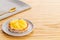 Pineapple tart or tartlet with grated coconut over grey napkin with a golden spoon on a wooden background with copy space