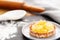 Pineapple tart or tartlet with grated coconut in a small plate on a slate with flour and baking utensils