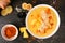 Pineapple, turmeric, ginger smoothie bowl. Overhead table scene on a dark slate background.