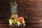 Pineapple, vivid grapefruit, pears, strawberries, leaves of mint, blueberries, lime and ice on a wooden brown background