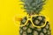 Pineapple wearing a pair of yellow eyeglasses