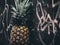 A pineapple wearing sunglasses against a graffiti covered wall. AI generative image.
