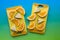 Pineapple wedges and navel orange slices on a bright yellow cutting board against a colourful background.