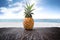 Pineapple on wooden desk and beach side background