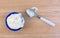 Pineapple yogurt on a wood table with spoon and spill