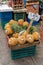 Pineapples displayed on a market, with a sign with the price in local currency (Mexican pesos), no people