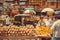Pineapples and oranges on marketplace for sell and many customers of busy street market