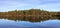 Pinewood, pine forest reflected in a lake in the wilderness of Norway, panorama