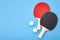 Pingpong lesson and winning competitive challenge concept with red and black table tennis or ping pong paddle isolated on blue