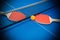 Pingpong rackets and ball highlighted on blue pingpong table
