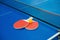 Pingpong rackets and ball and net on blue pingpong table