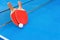 Pingpong rackets and ball and net on blue pingpong table