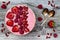 Pink acai, maca powder smoothie bowl topped with sliced strawberries, raspberries and goji berries.