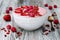 Pink acai, maca powder smoothie bowl topped with sliced strawberries, raspberries and goji berries.