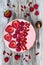 Pink acai, maca powder smoothie bowl topped with sliced strawberries, raspberries and goji berries.