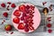 Pink acai, maca powder smoothie bowl topped with sliced strawberries, raspberries and goji berries.