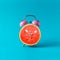 Pink alarm clock watermelon on blue background. Minimal concept