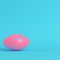 Pink american football ball on bright blue background in pastel colors