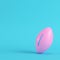 Pink american football ball on bright blue background in pastel colors